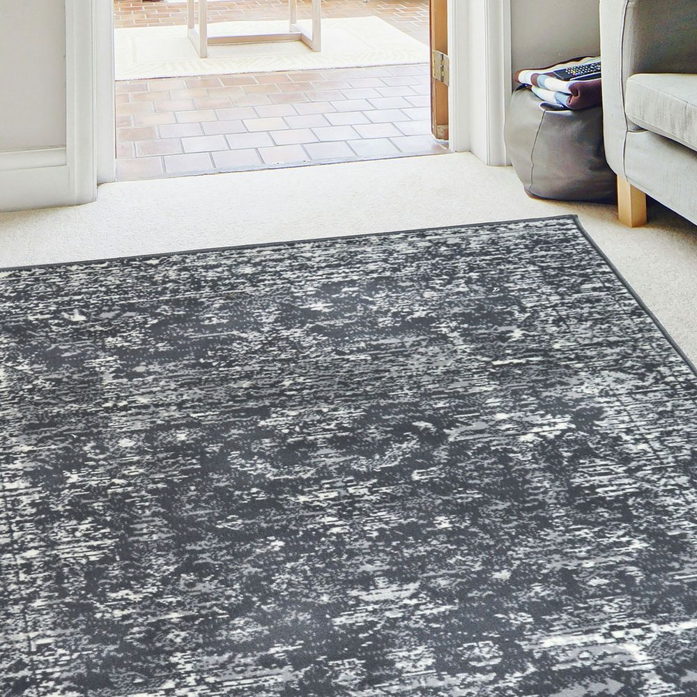 Grey and white abstract patterned area rug in modern living room with sofa and doorway