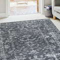 Grey and white abstract patterned area rug in modern living room with sofa and doorway