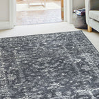 Grey and white abstract patterned area rug in modern living room with sofa and doorway