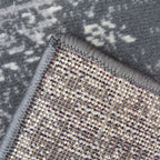 Grey abstract patterned rug with textured weave and fringed edge, ideal for modern living spaces