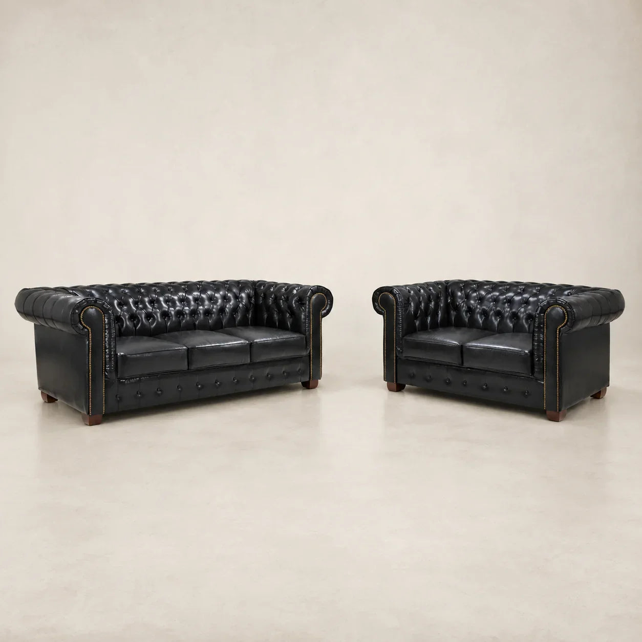 Black leather Chesterfield sofa and loveseat set with tufted design and rolled arms