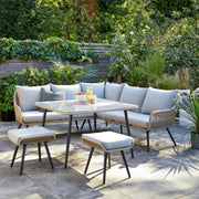 Luxury outdoor wicker sofa set with glass table and cushions on patio, perfect for garden dining