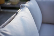 Luxury outdoor sofa with plush light grey cushions and woven frame, perfect for garden relaxation.