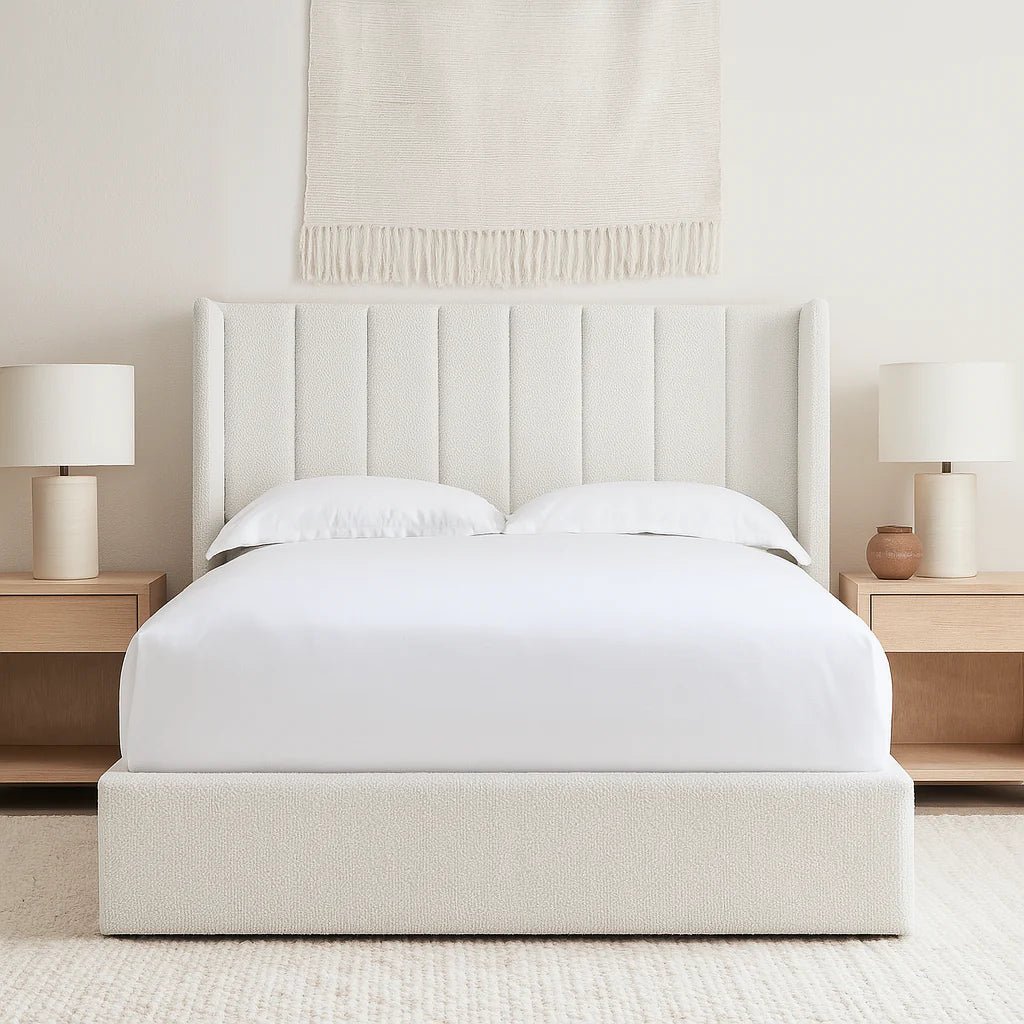 Modern upholstered bed with vertical panel headboard, flanked by wooden bedside tables and lamps