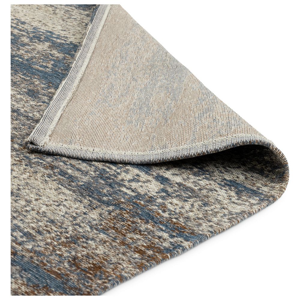 Blue and beige patterned area rug with textured weave and folded corner detail