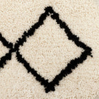 Cream wool rug with black diamond pattern, cozy textured floor covering for living room