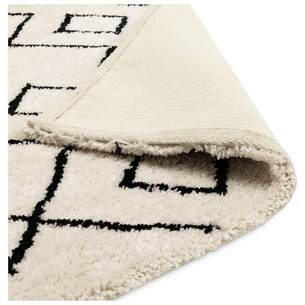 Cream rug with black geometric pattern and fringed edge, luxury home decor