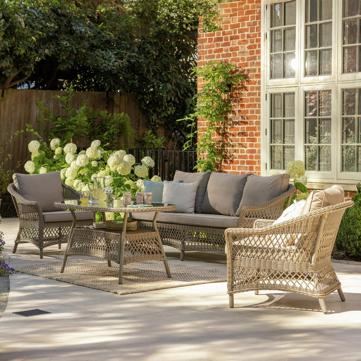 Luxury wicker outdoor sofa set with cushions on patio, perfect for garden relaxation and alfresco living