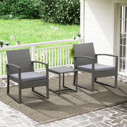 Grey wicker outdoor patio furniture set with armchairs and side table on stone deck