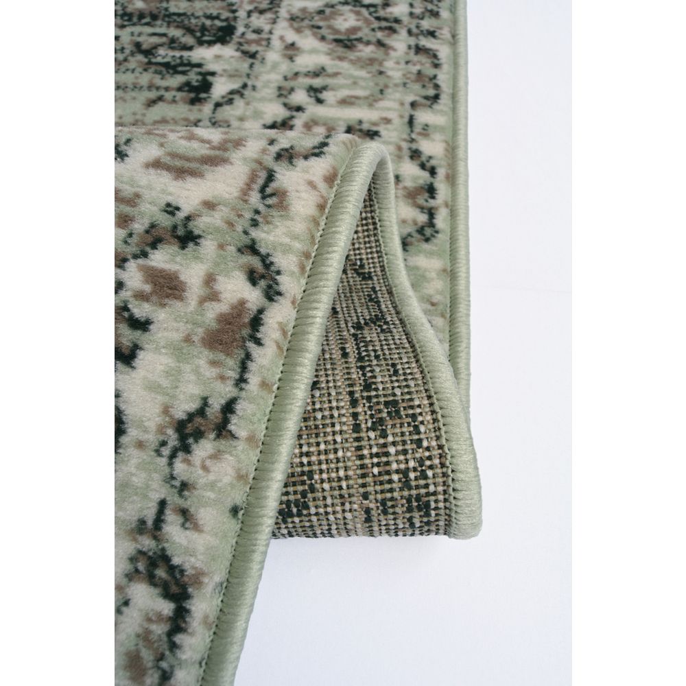 Vintage-style area rug with green, beige, and black floral pattern and piped edge