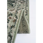 Vintage-style area rug with green, beige, and black floral pattern and piped edge