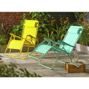 Bright yellow and mint green outdoor lounge chairs on patio with garden backdrop