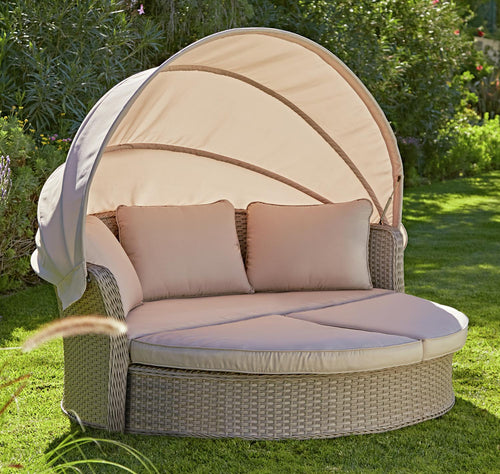 Luxury wicker garden daybed with canopy, plush cushions, perfect for outdoor relaxation in UK gardens