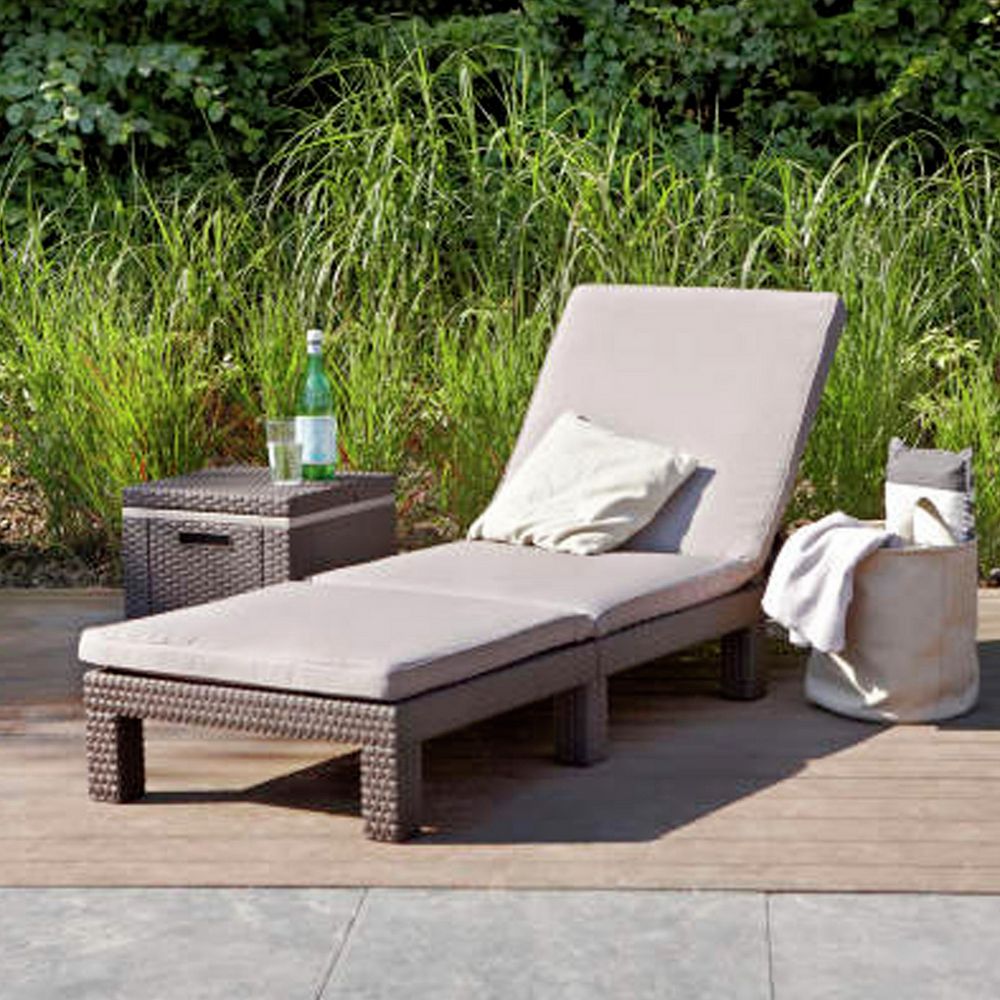 Luxury outdoor wicker chaise lounge with beige cushion on patio, perfect for garden relaxation