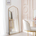 Gold-framed full-length mirror with scalloped top and shelf, styled in luxury bedroom with vanity chair