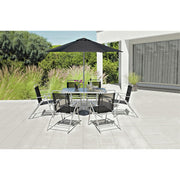 Modern outdoor dining set with glass table, black chairs, and umbrella on patio