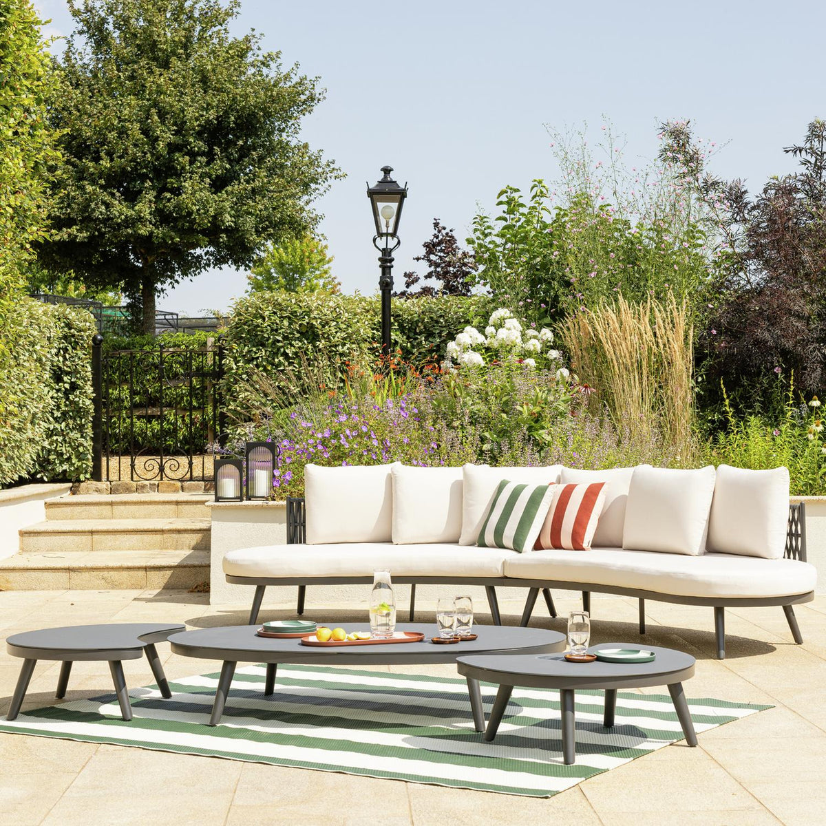 Luxury outdoor sofa set with striped cushions on patio, perfect for garden relaxation and al fresco living.