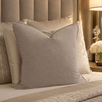 Luxury velvet bed pillows in neutral tones, styled on a plush upholstered bed with ambient bedside lighting.