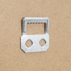 Metal sofa bed frame connector with two holes and serrated edge on cardboard background