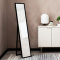 Black full-length floor mirror with A-frame stand in modern living room, beside white sideboard and lamp
