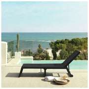 Black outdoor lounge chair by infinity pool with ocean view, perfect for luxury patio relaxation