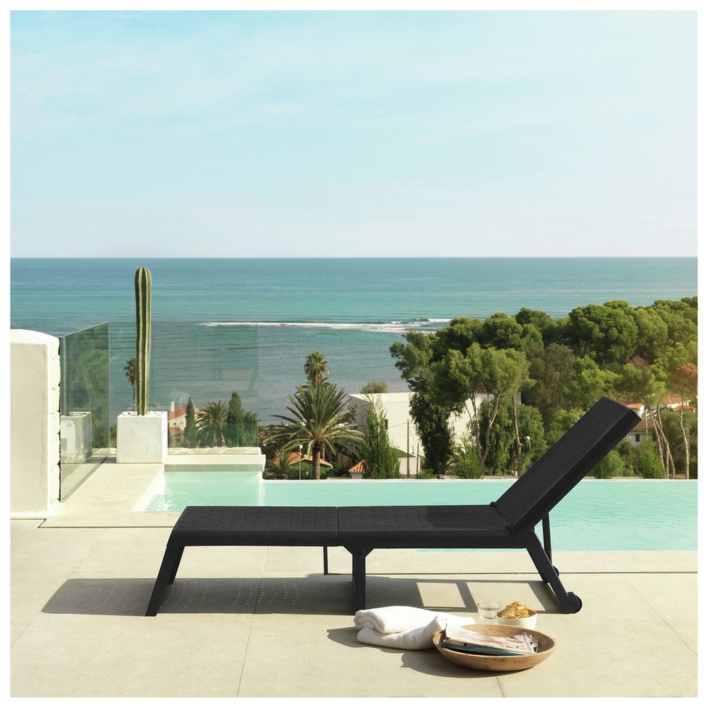 Black outdoor lounge chair by infinity pool with ocean view, perfect for luxury patio relaxation