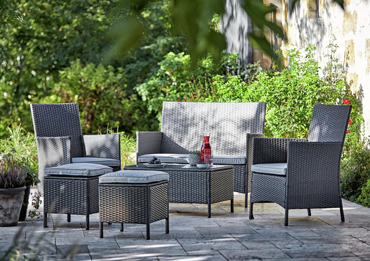 Grey wicker outdoor sofa set with cushions on patio, perfect for garden relaxation