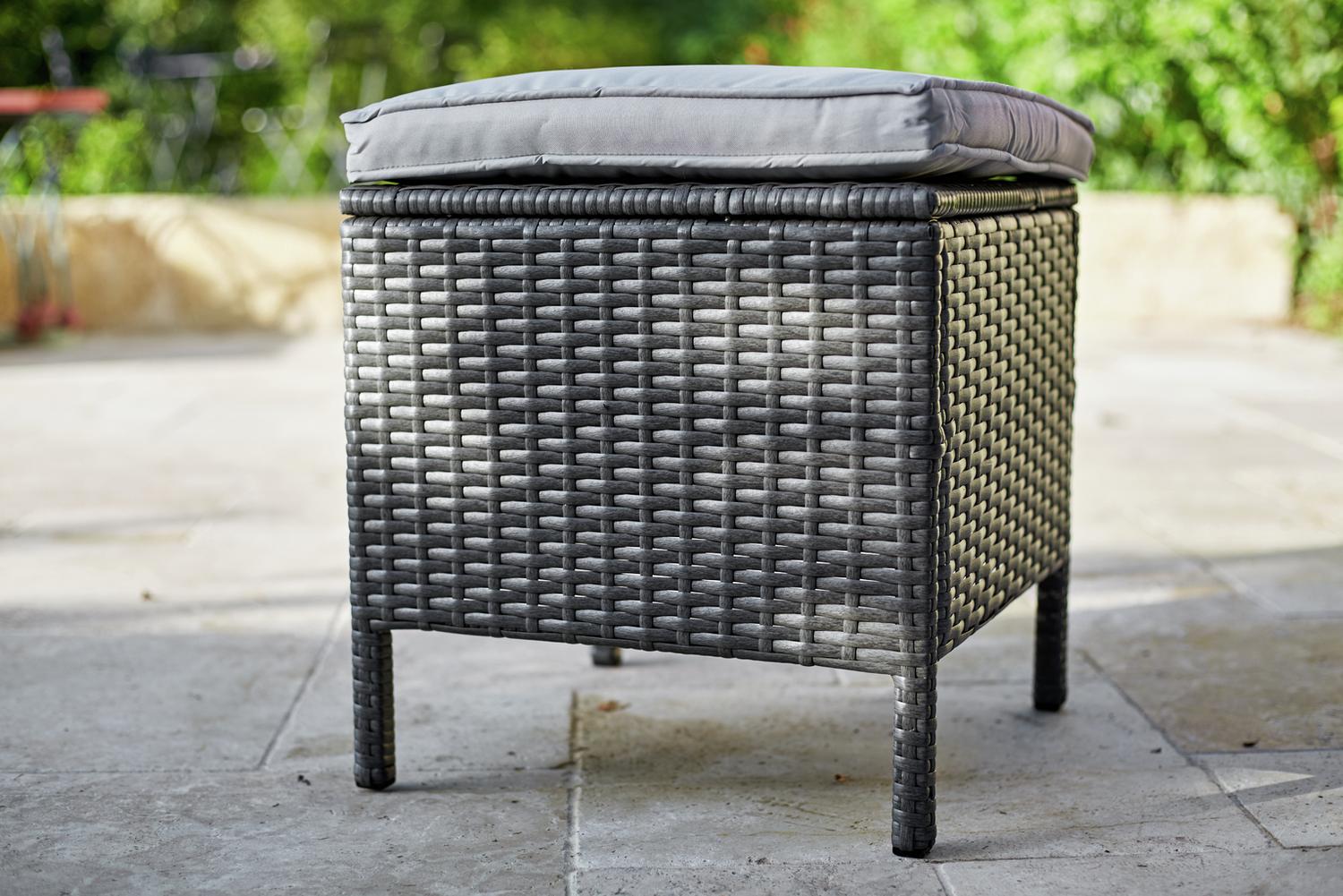 Grey wicker outdoor ottoman with cushion on patio, perfect for garden seating