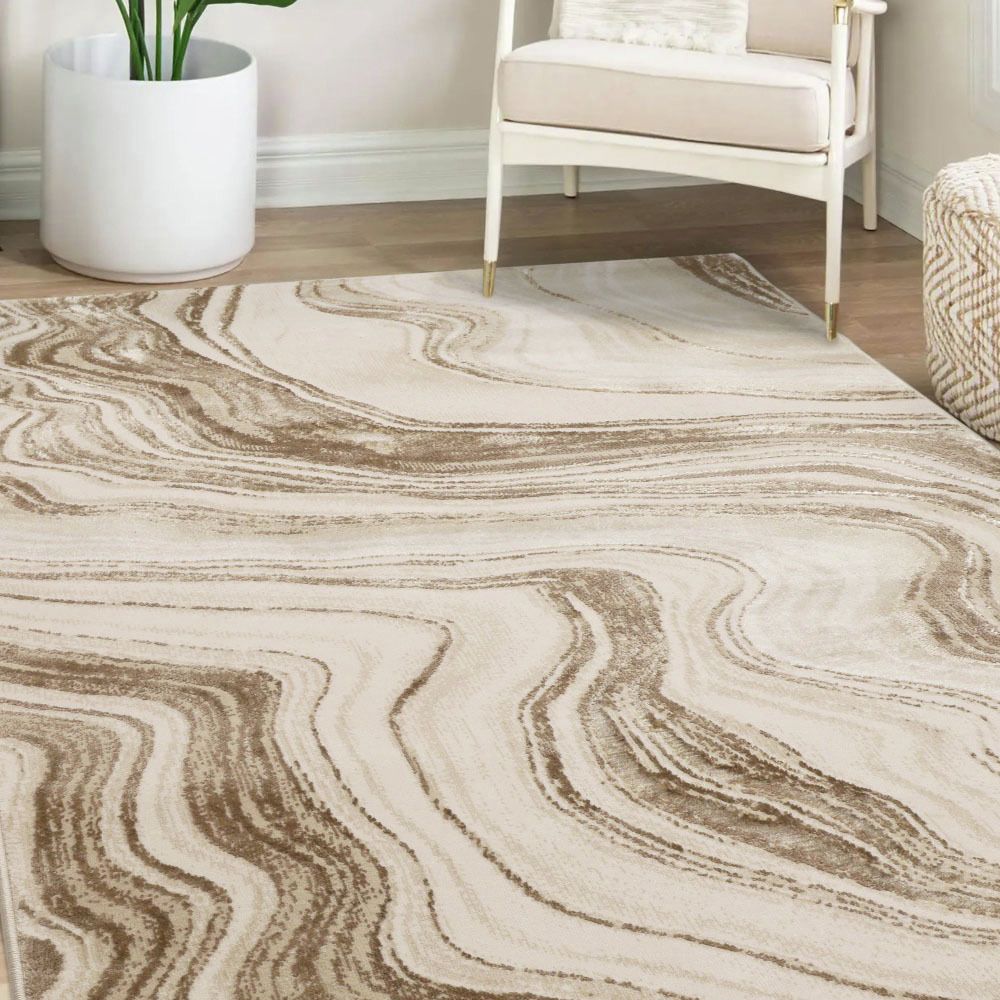 Beige and brown abstract wave pattern area rug in modern living room with white armchair