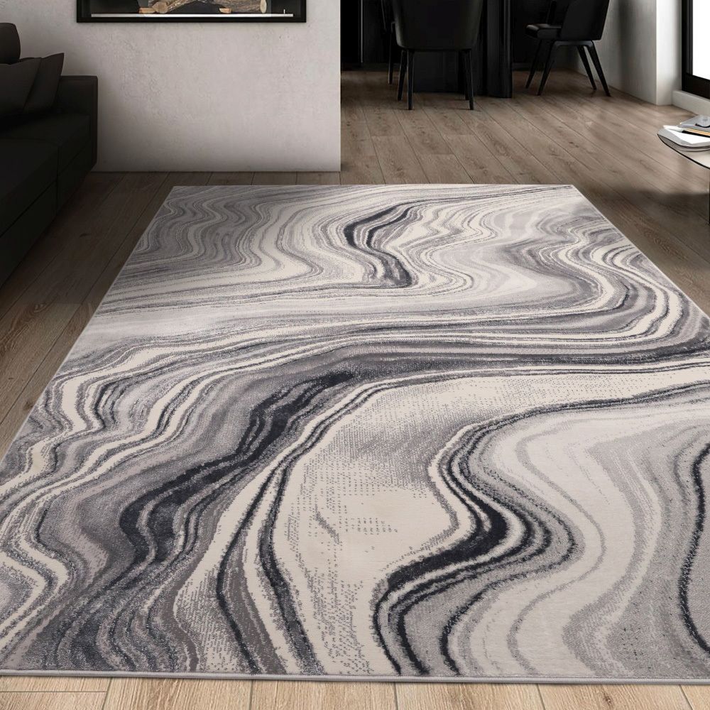 Gray and white abstract wave pattern area rug in modern living room with wooden floors