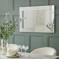 Luxury chrome-framed mirror above dining table with floral centerpiece, modern home decor