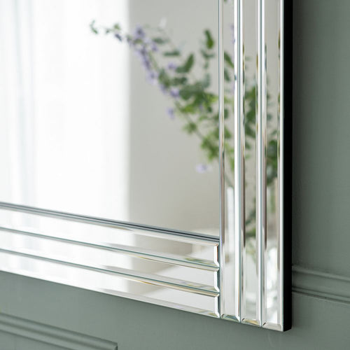 Luxury beveled mirror with sleek frame, reflecting flowers, perfect for modern home decor