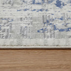 Soft blue and white patterned area rug on hardwood floor, plush texture detail