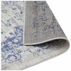 Blue and white distressed pattern area rug with textured weave and stitched edge