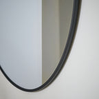 Modern oval wall mirror with sleek black frame, perfect for contemporary home decor