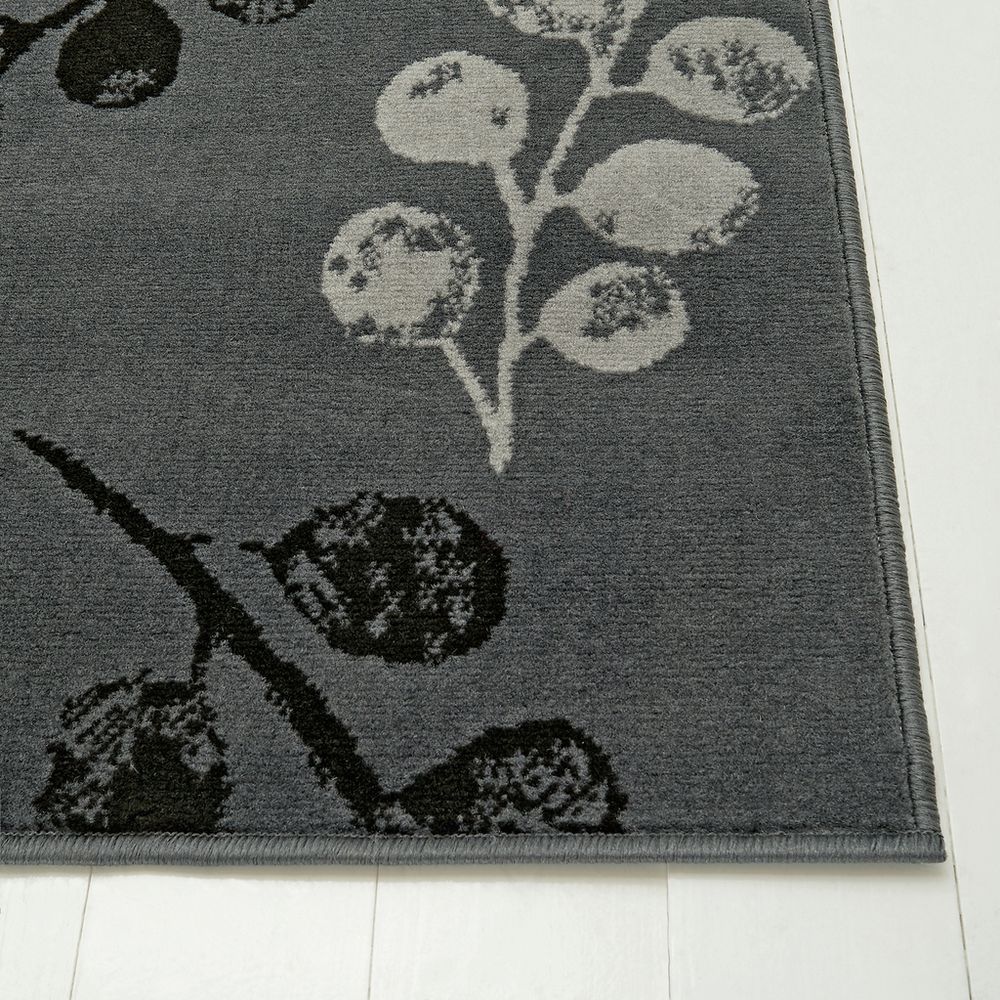 Gray area rug with floral pattern, soft texture, placed on white wood floor for modern home decor