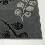 Gray area rug with floral pattern, soft texture, placed on white wood floor for modern home decor