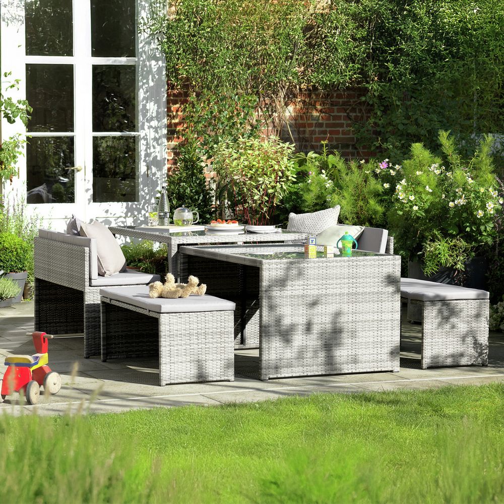 Grey wicker outdoor dining set with cushions on patio, perfect for garden entertaining
