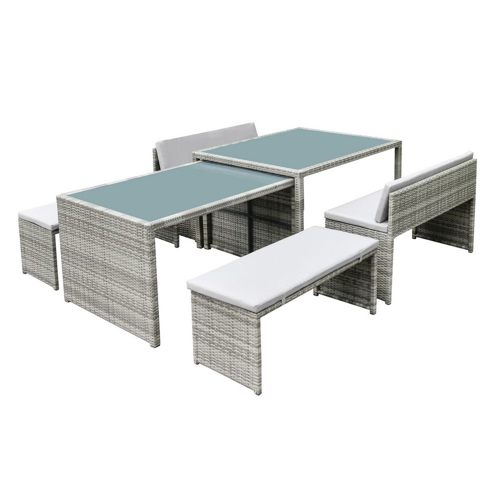 Grey wicker outdoor dining set with glass tables and white cushions