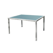 White wicker outdoor dining table with blue glass top, perfect for patio or garden use.