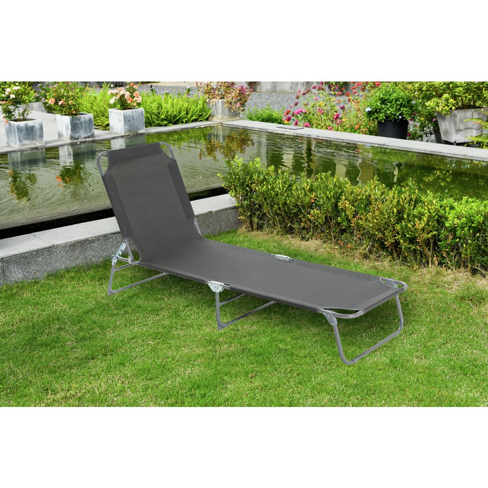 Grey outdoor lounge chair on grass by poolside garden