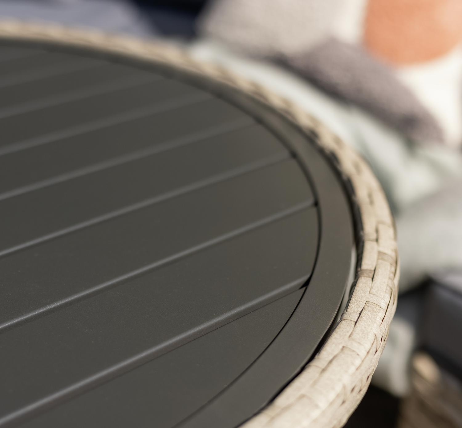 Round outdoor table with dark slatted top and woven edge, perfect for patio or garden furniture sets