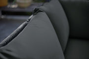 Luxury dark grey sofa with plush cushions and textured weave armrest, perfect for modern living rooms.