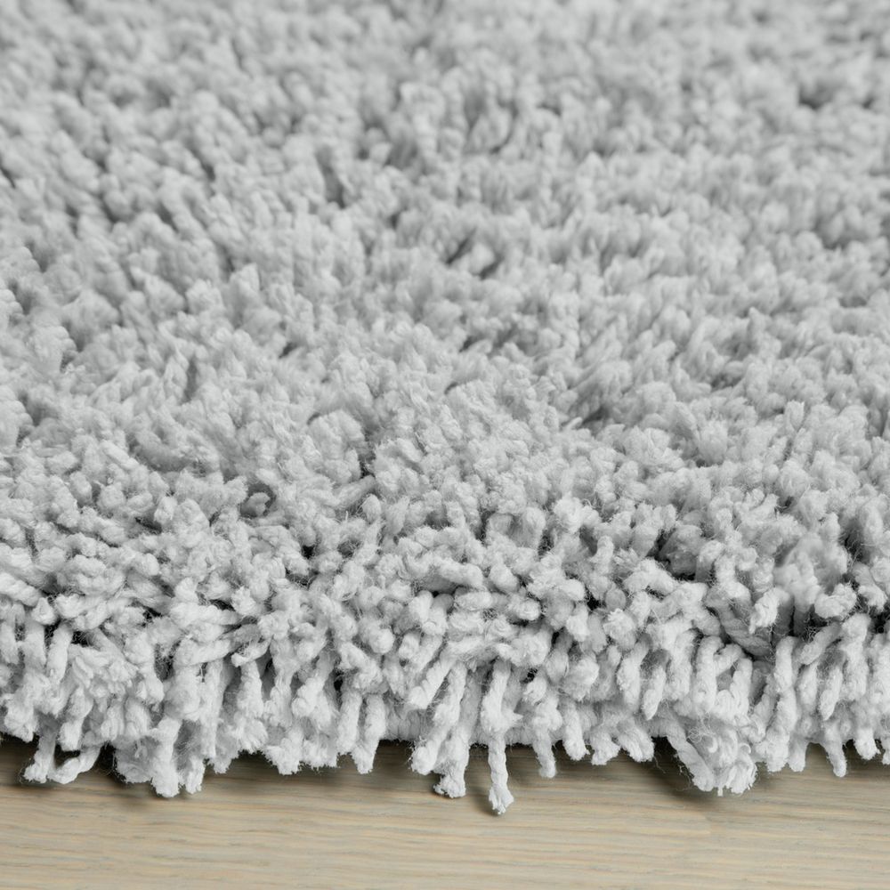 Soft grey shaggy rug on wooden floor, cozy luxury home decor