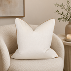 Cream velvet cushion with gold trim on cozy bouclé armchair, luxury home decor