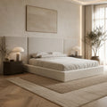 Luxury beige upholstered bed with modern headboard, bedside tables, and ambient lighting in neutral bedroom