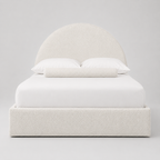Luxury upholstered bed with curved headboard, white bedding, and textured fabric for modern bedroom