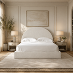 Luxury upholstered bed with curved headboard in neutral bedroom, white linens, matching nightstands and lamps