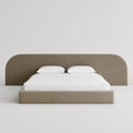 Modern upholstered bed with curved headboard, white linens, luxury bedroom furniture
