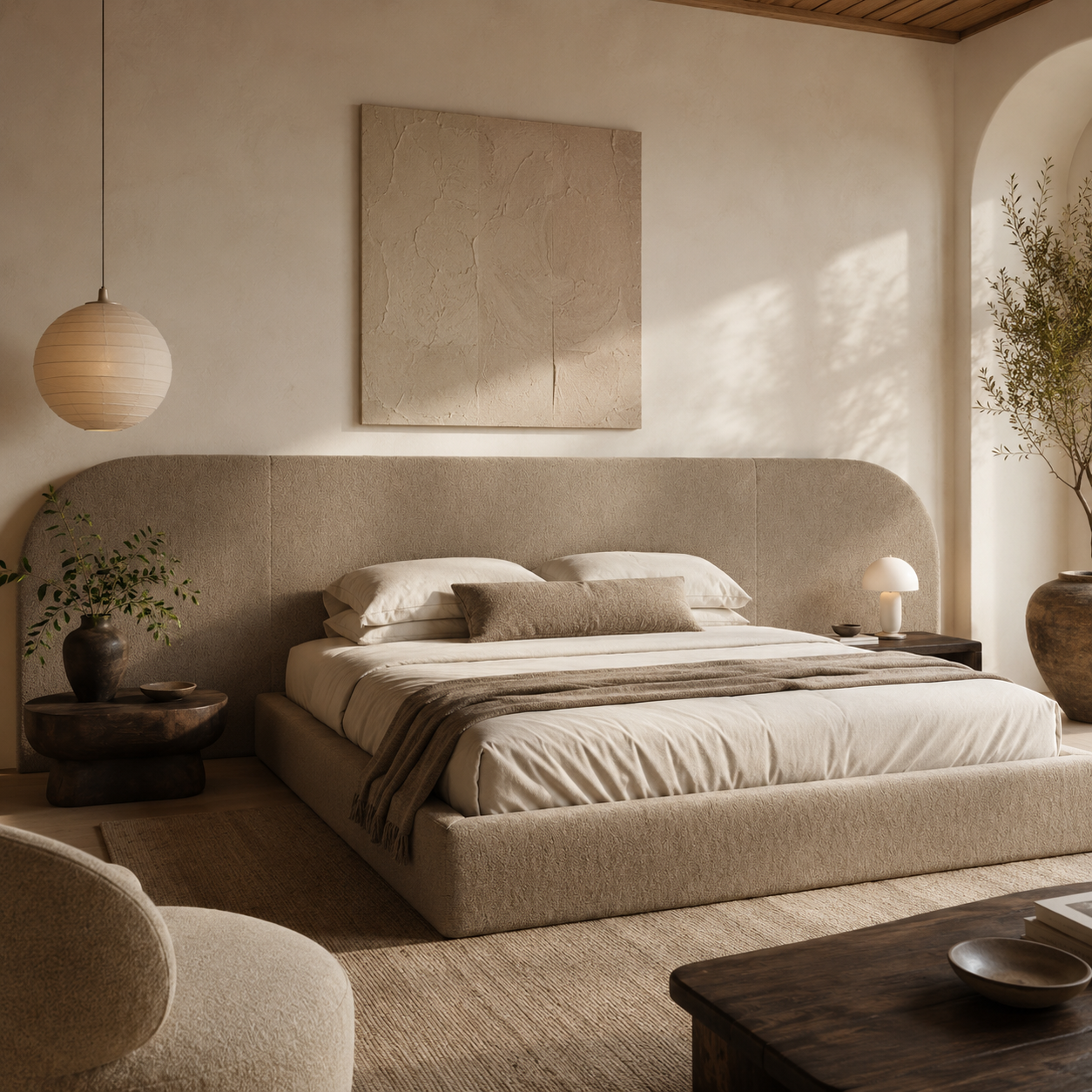 Luxury upholstered bed with curved headboard in neutral tones, styled with linen bedding and modern bedside lamps